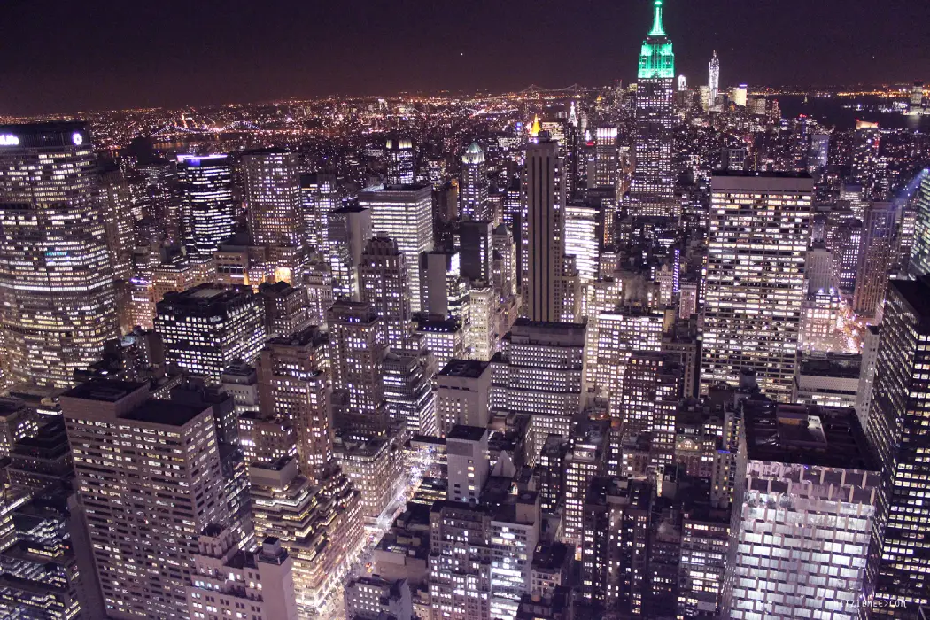 Aerial view of Midtown Manhattan lit up under the night sky